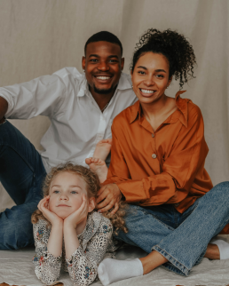 Black couple posing in front of the camera with a young girl