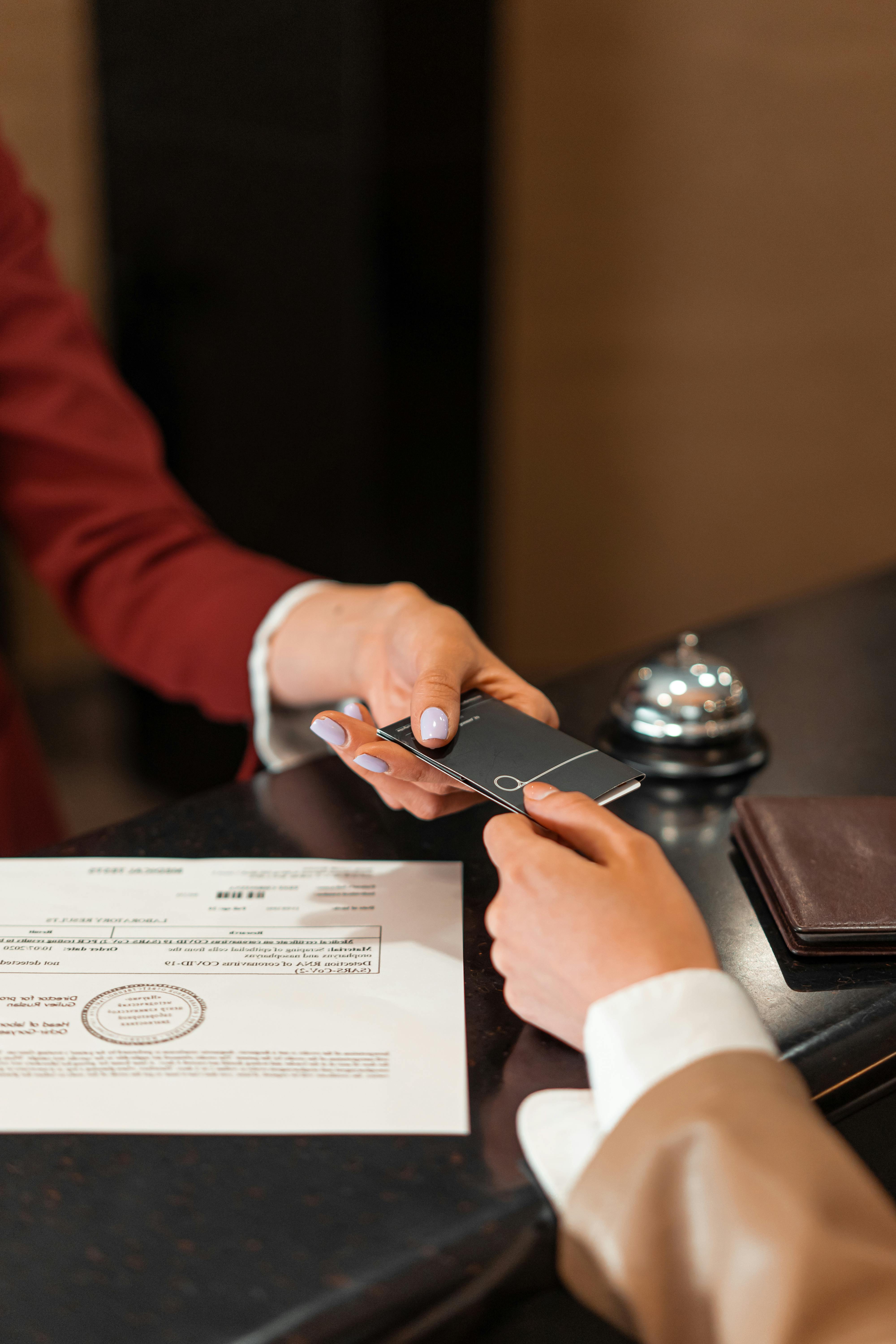 A hotel receptionist hands a keycard to a customer